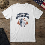 White t-shirt with line art of a grandfather walking a toddler by pines and the words "Reporting for Grandpa Duty"