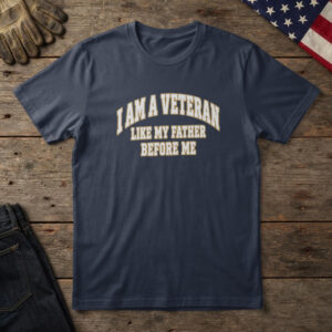 Navy t-shirt with eagle, flag and stacked type and the words "I Am a Veteran Like My Father Before Me", on wood