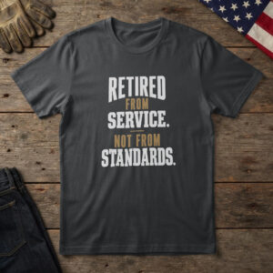 Black t-shirt with white and brass type, "Retired From Service. Not From Standards." on wood with a US flag