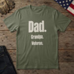 Military Green t-shirt with stacked parchment type reading "Dad. Grandpa. Veteran." on wood with a US flag