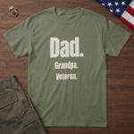 Military Green t-shirt with stacked parchment type reading "Dad. Grandpa. Veteran." on wood with a US flag