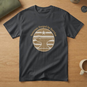 Black t-shirt with a brass badge of an anvil under a star and the words "Veteran: Forged by Service", on wood with a flag