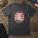 Black t-shirt with a scowling white bald eagle in a red striped circle and the words "Grumpy Old Veteran", on wood