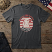 Black t-shirt with a scowling white bald eagle in a red striped circle and the words "Grumpy Old Veteran", on wood