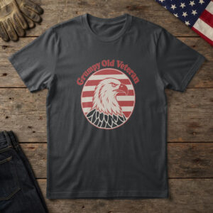 Black t-shirt with a scowling white bald eagle in a red striped circle and the words "Grumpy Old Veteran", on wood