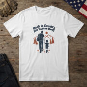 White t-shirt with line art of a dad with a duffel bag walking his child by pines and "Back in Country for Father Duty"