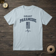 Chambray t-shirt with a small navy flag with one white stripe, a heartbeat line and the words "GRANT PARAMEDIC"