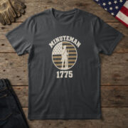 Black t-shirt with a colonial minuteman in a tricorn hat, musket at rest, on a flag badge and the words "Minuteman 1775"