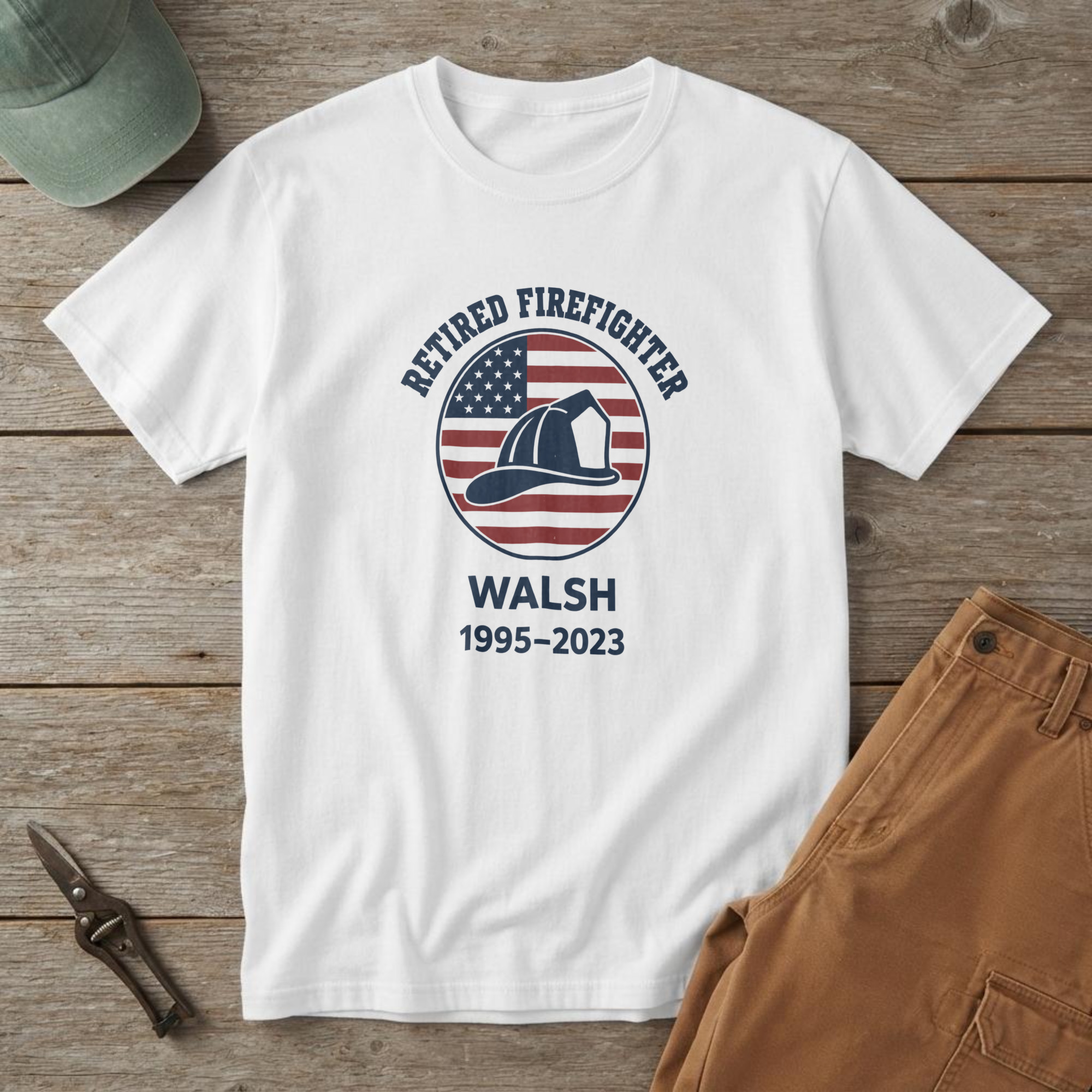 lfb-hero-15106 White t-shirt with a navy helmet on a red and white striped flag badge and "RETIRED FIREFIGHTER WALSH 1995-2023"