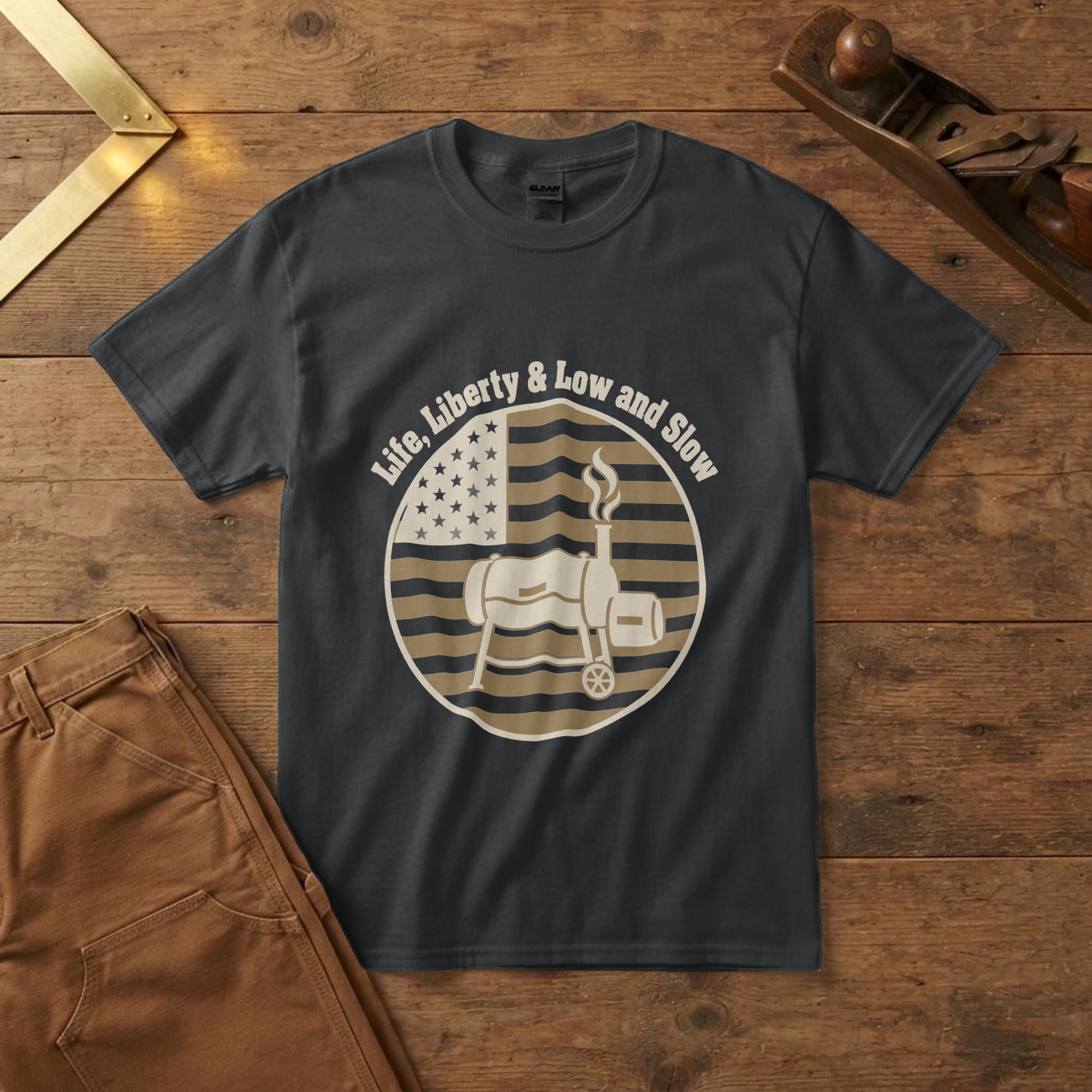 lfb-hero-15221 Black t-shirt with a barrel smoker and rising smoke inside a flag badge and the words "Life, Liberty & Low and Slow", wood
